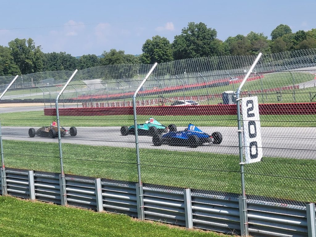 Formula cars racing past the 200 marker at Mid-Ohio