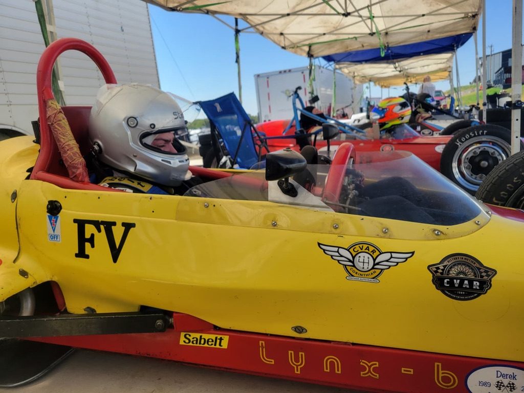 Sergio Ostos in the cockpit of a yellow Formula Vee